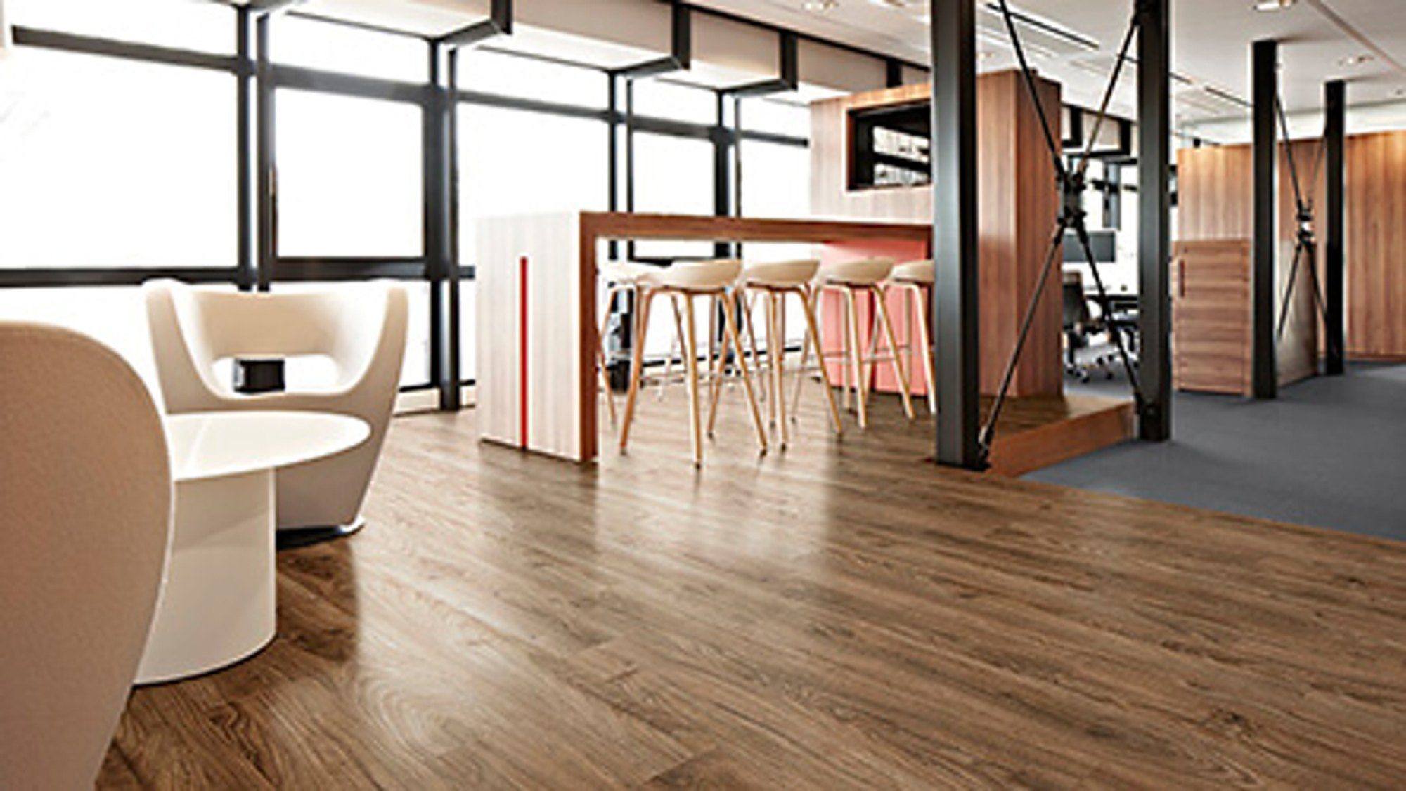 Kantoor met houten vloer, statafel en loungestoelen