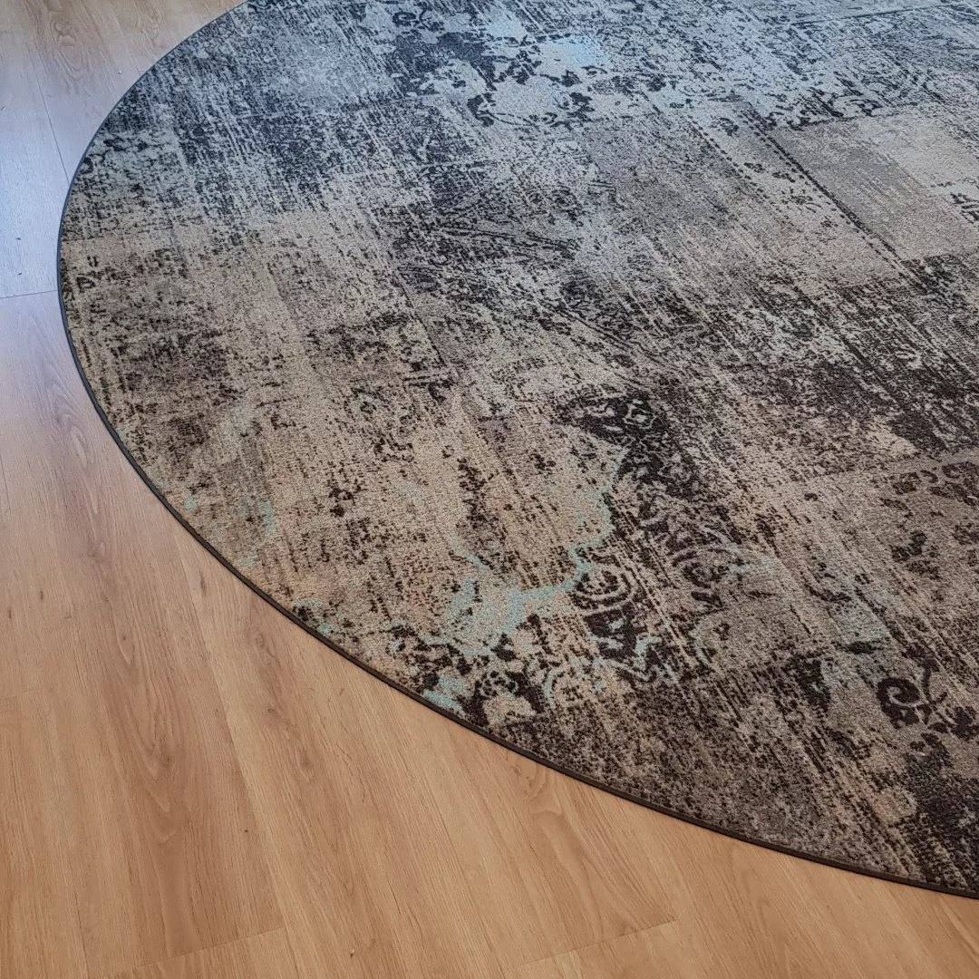 Rond tapijt ingelegd in een vloer in houtlook
